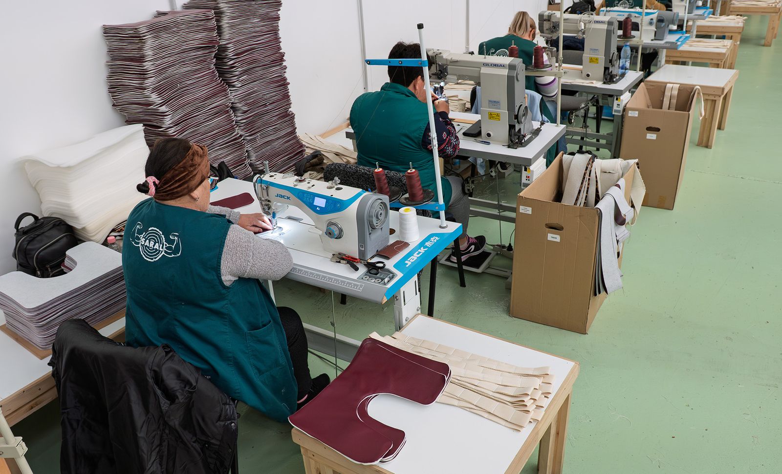 Upholsterers sewing seat covers at the SARAL upholstery and stitching line
