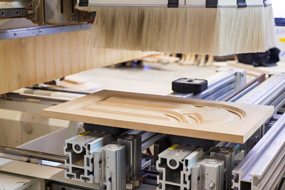 Router CNC care frezează un profil într-o piesă de lemn