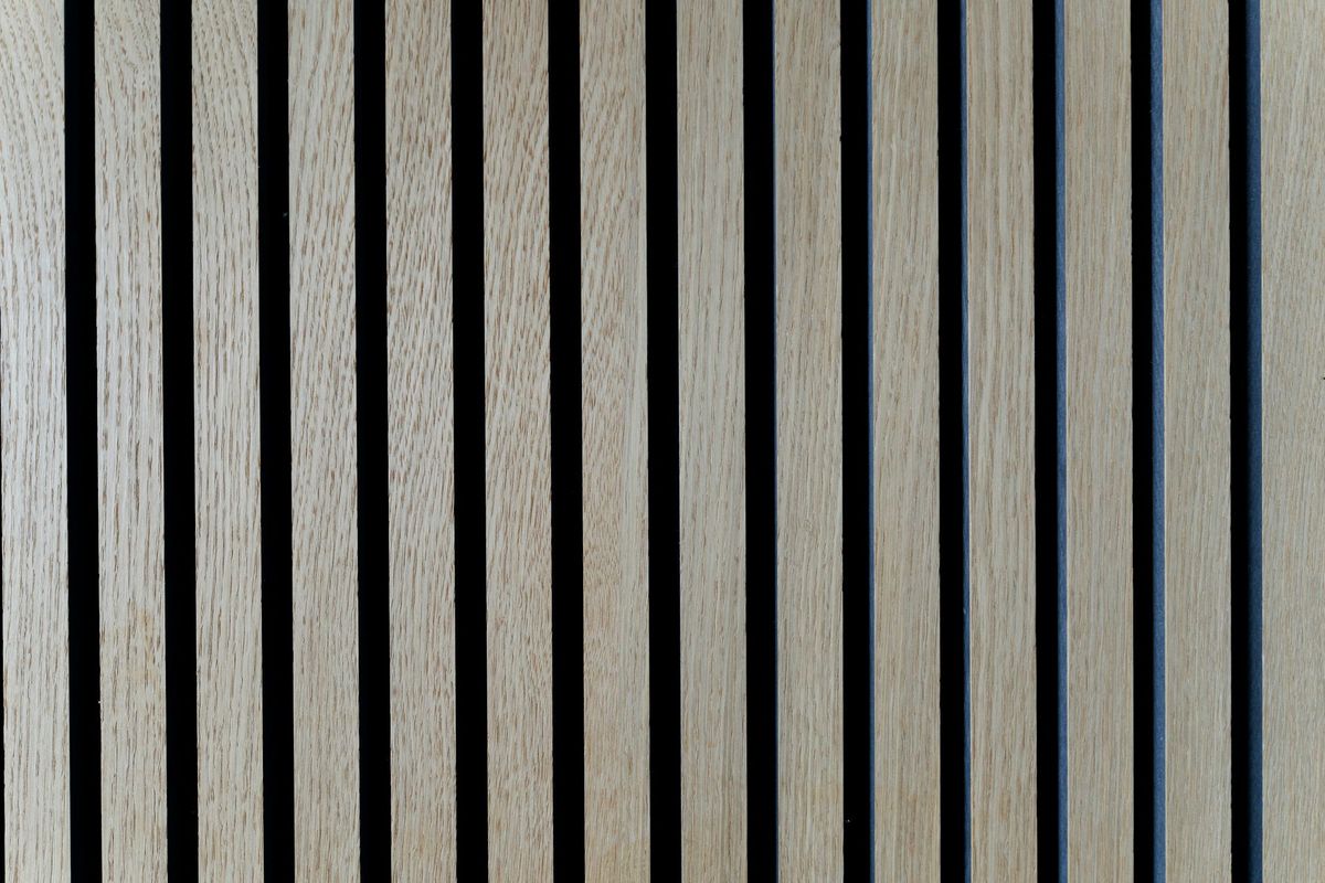 Close-up of light wood slats with black acoustic felt visible in the narrow gaps